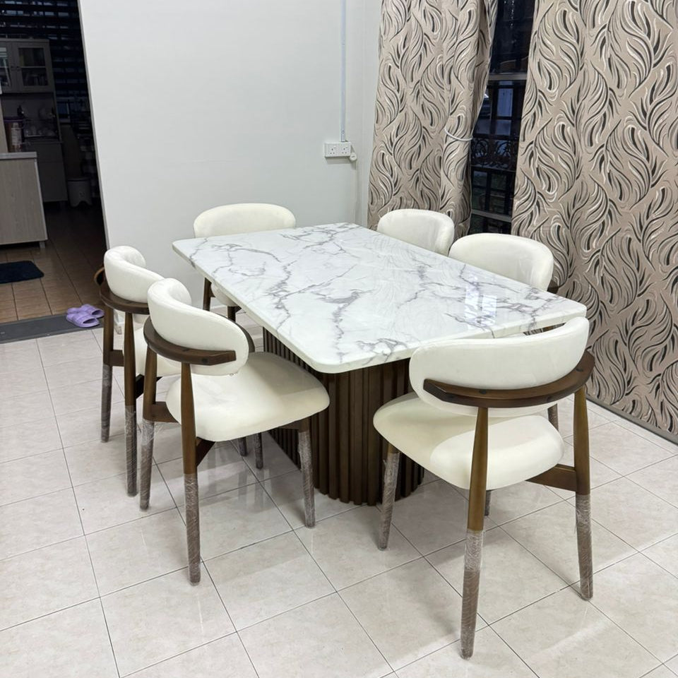 A modern 6-piece dining set featuring a rectangular white marble-patterned table with a fluted dark brown base, surrounded by six chairs with cream upholstered seats and backs, dark wood armrests, and silver metal legs.