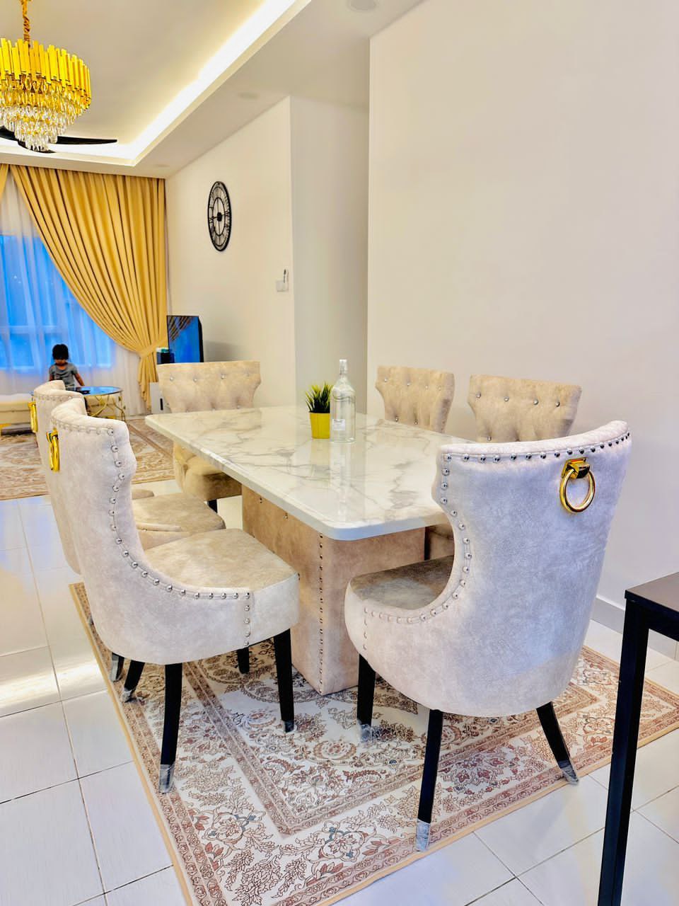 Butterfly marble dining table with cream velvet chairs in home dining area
