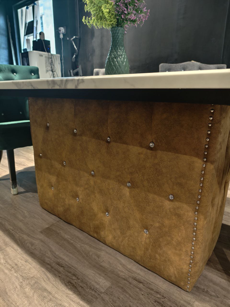 Marble dining table with tufted pedestal base in showroom
