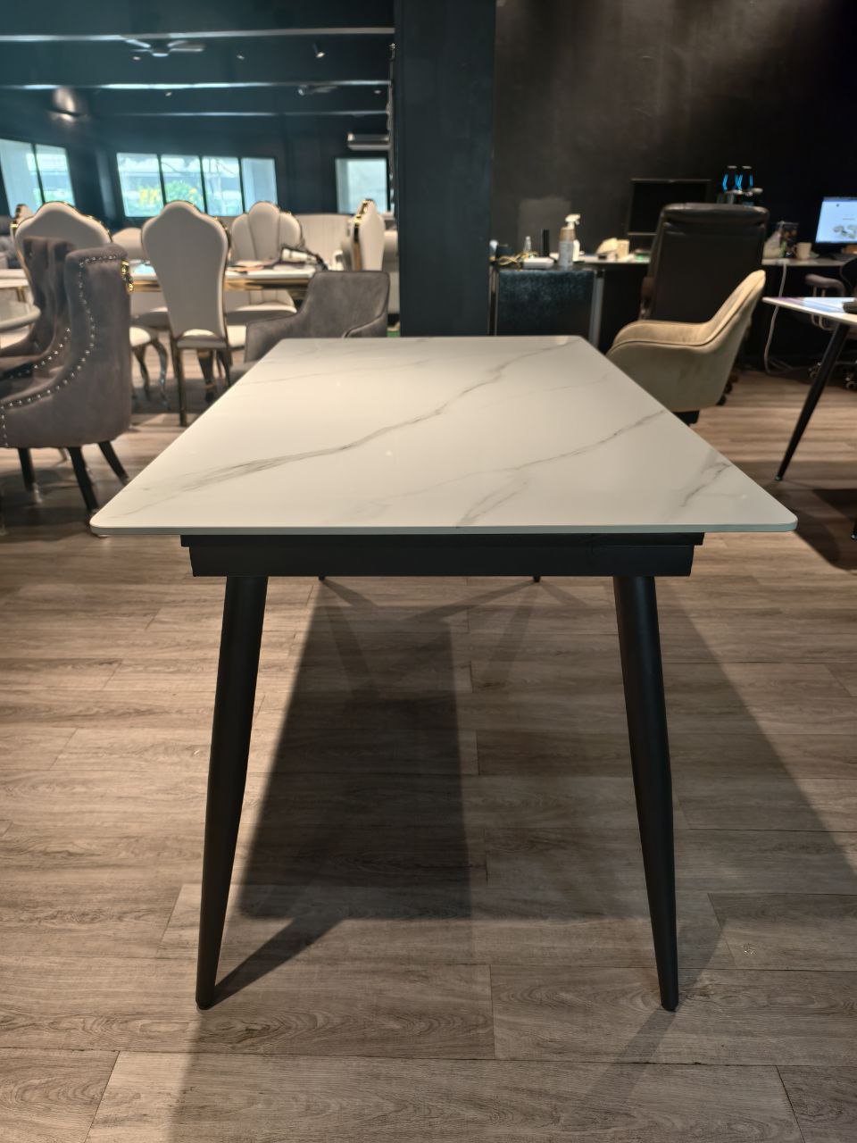 Grey upholstered dining chair beside marble-look dining table