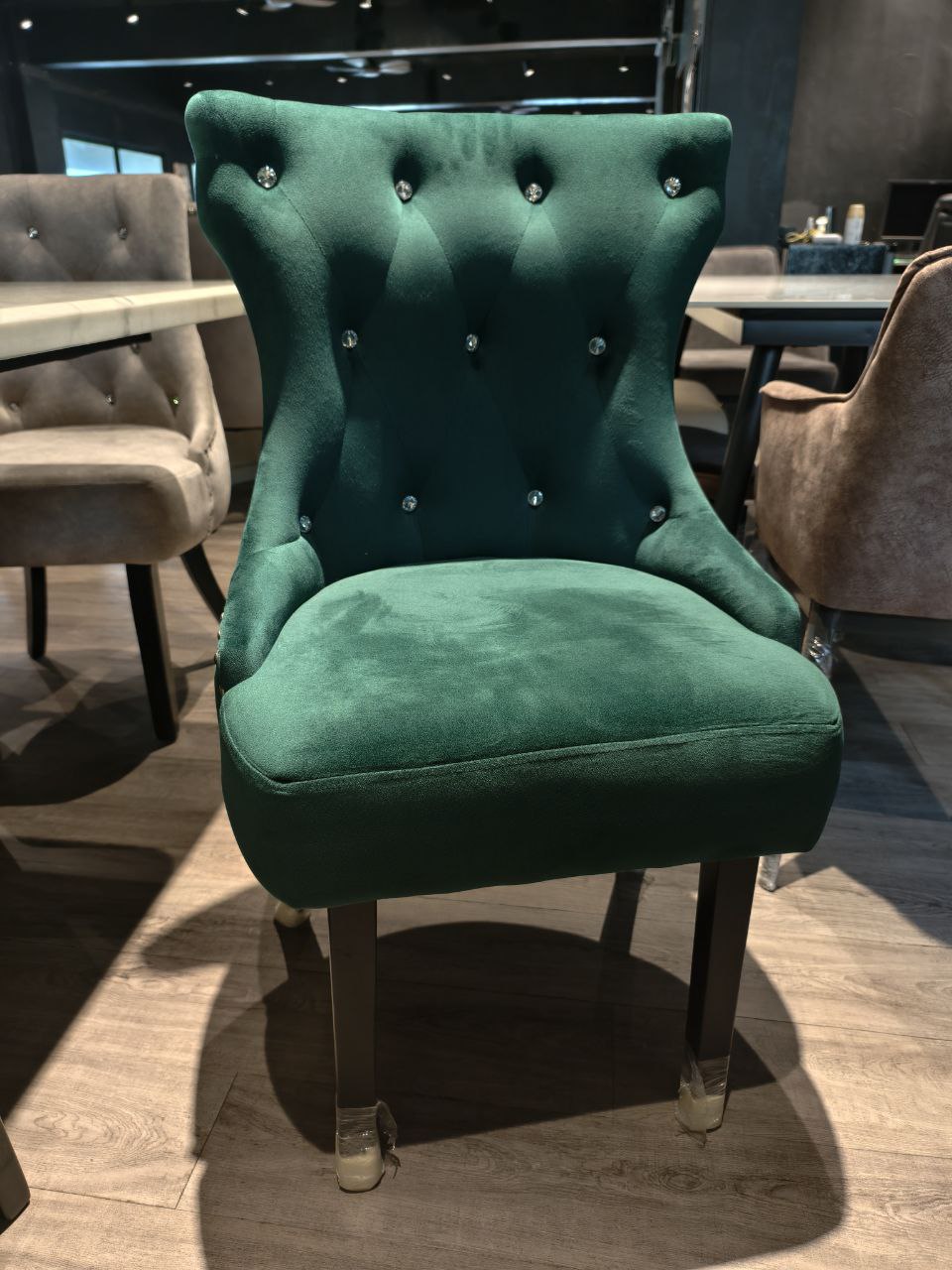 Green velvet Butterfly dining chair front view in showroom