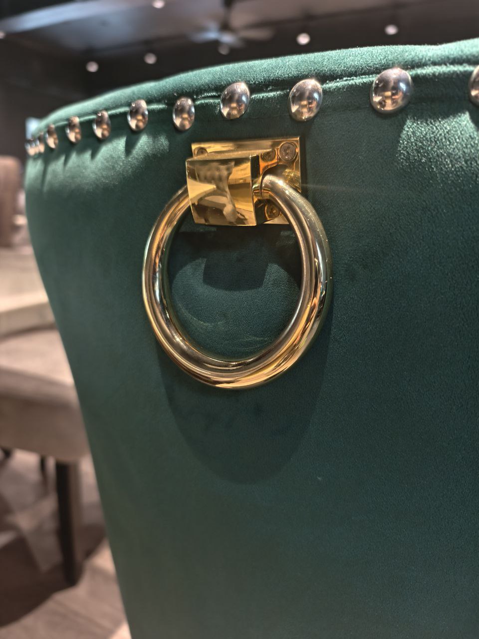 Gold ring handle detail on green velvet Butterfly dining chair