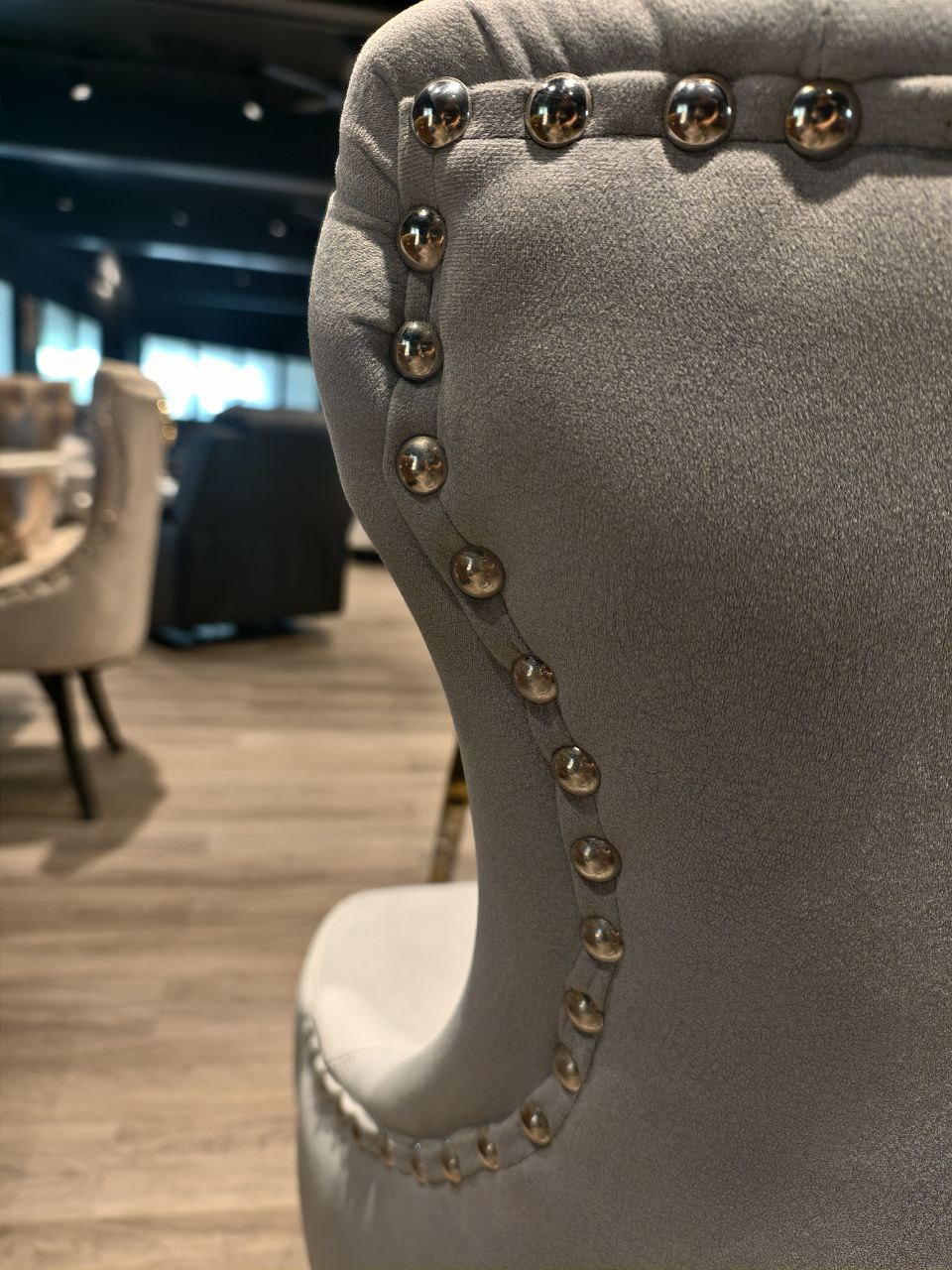 Close-up of nailhead trim on grey Butterfly dining chair back