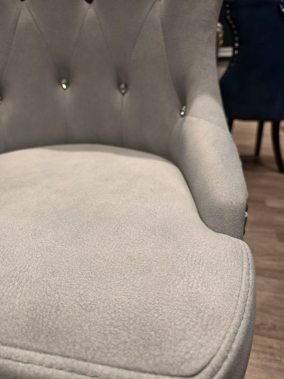 Close-up of grey velvet Butterfly dining chair seat and tufted back